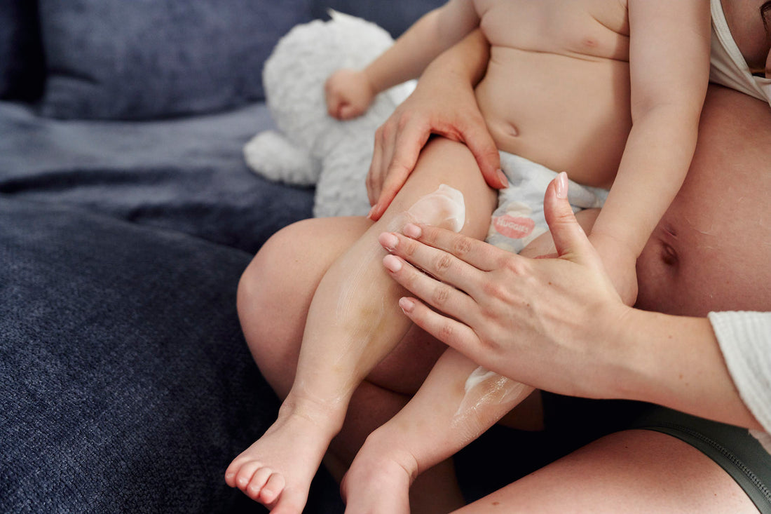 Baby, skincare being rubbed in by adult