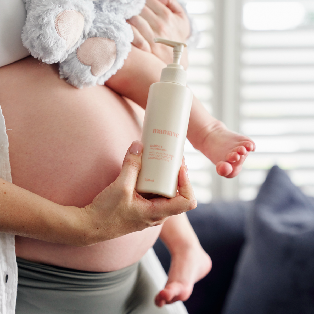 bubbas massage oil held by pregnant mum whilst holding her baby
