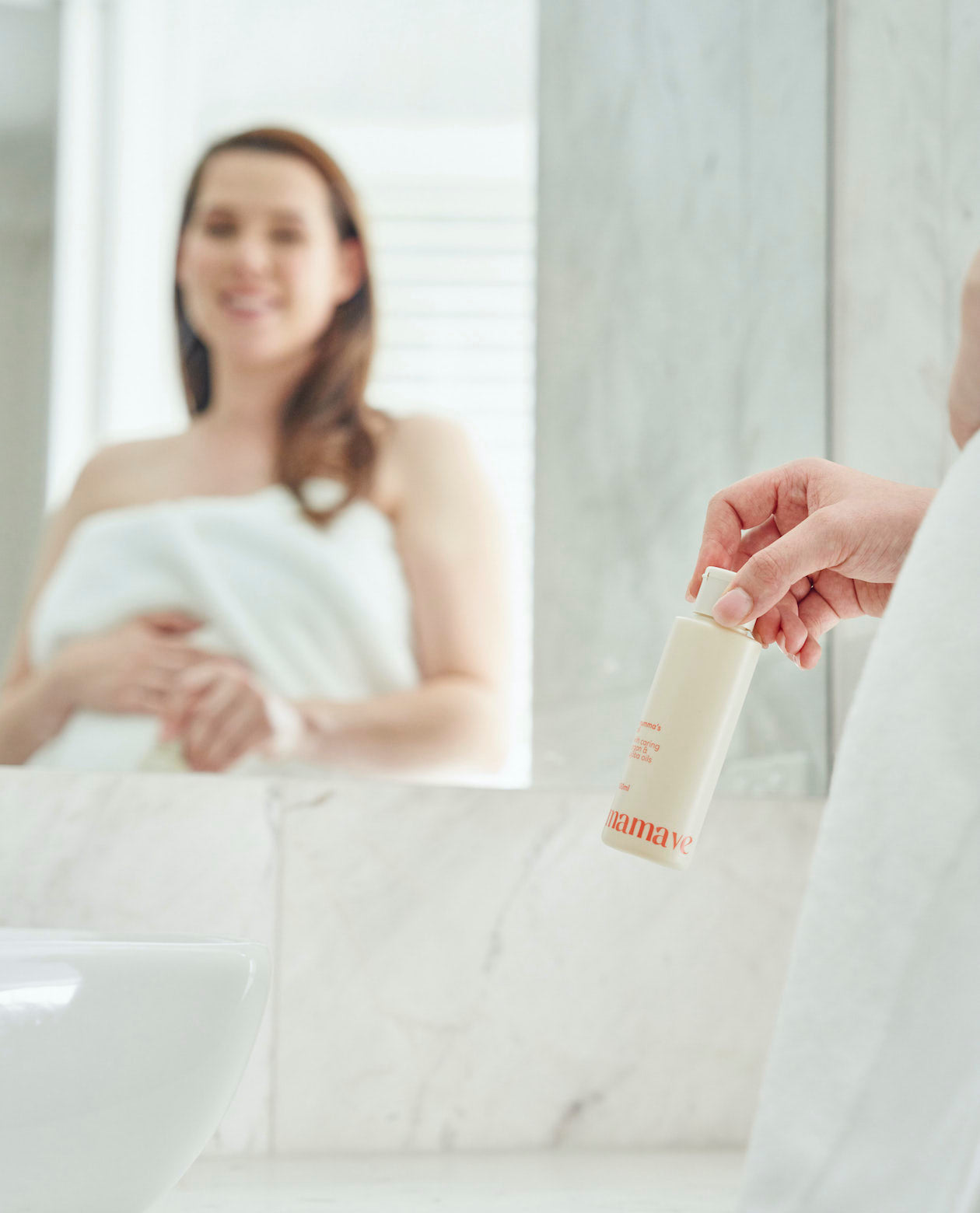 mirror reflection of woman holding massage oil